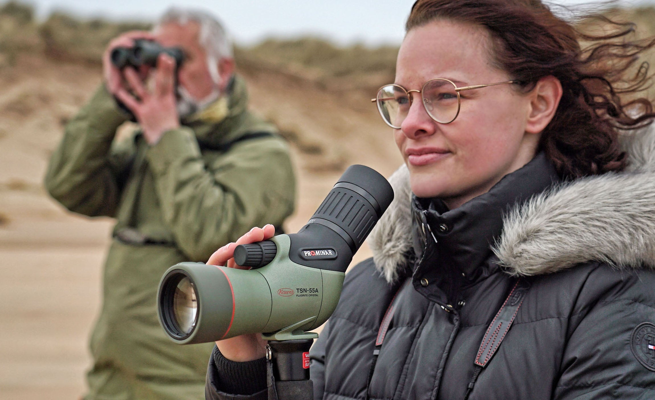 A user enjoys the Kowa TSN-55S PROMINAR Straight Spotting Scope on a beach, capturing stunning nature views.